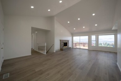 Unfurnished living room featuring recessed lighting, light wood finished floors, a brick fireplace, and high vaulted ceiling