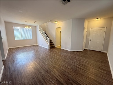 Unfurnished living room featuring a chandelier, st