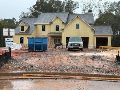 View of front facade featuring roof with shingles, a garage, a chimney, and board and batten siding