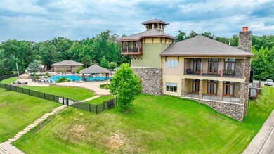 Back of property featuring stone siding, a gazebo, a chimney, a balcony, and a patio
