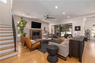Living room with a ceiling fan, a fireplace, recessed lighting, light wood-style flooring, and stairway