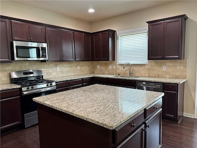 Kitchen with dark wood finished floors, stainless 