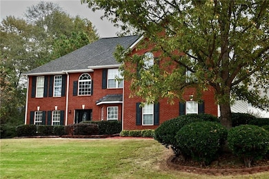 Colonial inspired home with a front lawn and brick siding