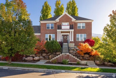 Colonial-style house featuring brick siding and a balcony