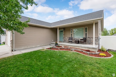 View of front of property featuring an attached garage, a porch, a front yard, and roof with shingles