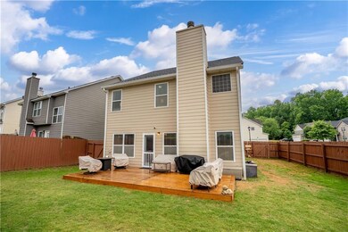 Back of house with a chimney and a deck