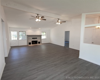 Great room with wood burning fireplace & double ceiling fans.