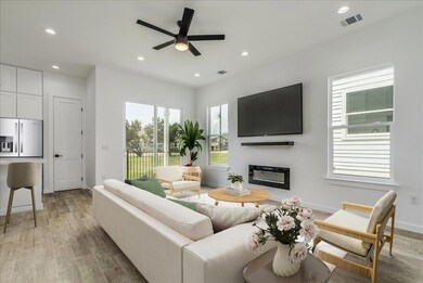 Open living area with kitchen, dining, and access to outdoor patio.