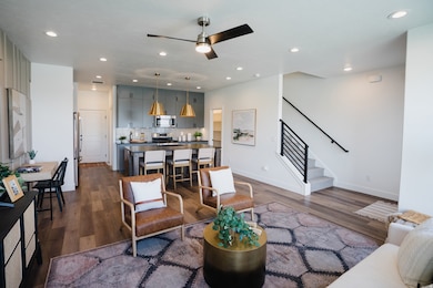 Living area with dark wood-style flooring, stairway, recessed lighting, and a ceiling fan