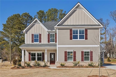 Craftsman-style house with board and batten siding, covered porch, and a shingled roof