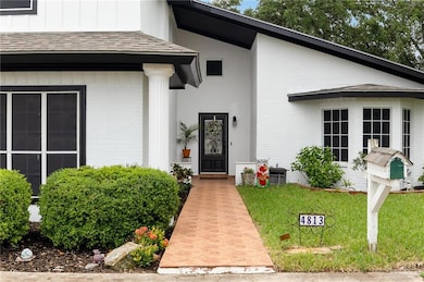 Property entrance with brick siding and a shingled roof