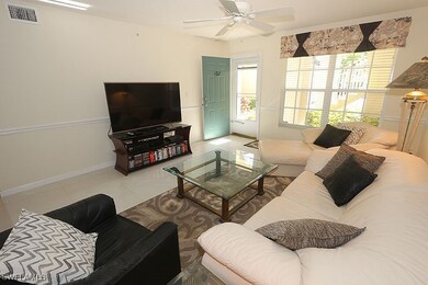 Tiled living room with ceiling fan and baseboards