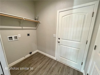 Clothes washing area with washer hookup, dark wood