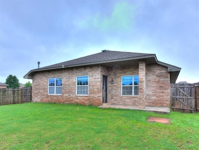 Back of property with brick siding and a shingled roof