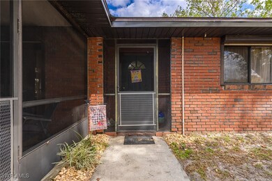Doorway to property featuring brick siding