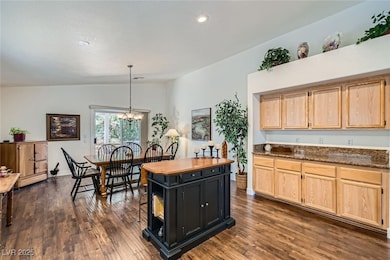 Kitchen featuring light brown cabinetry, lofted ce