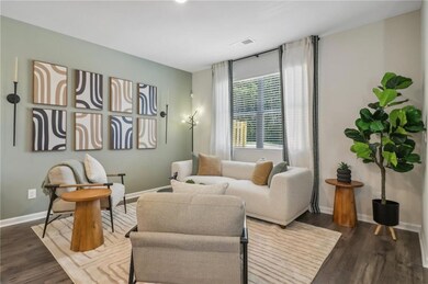Living room with dark wood-type flooring and baseboards