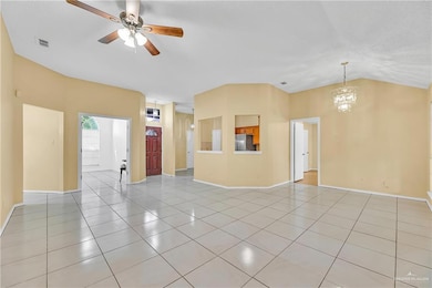 Unfurnished living room with lofted ceiling, light tile patterned floors, a chandelier, and a ceiling fan