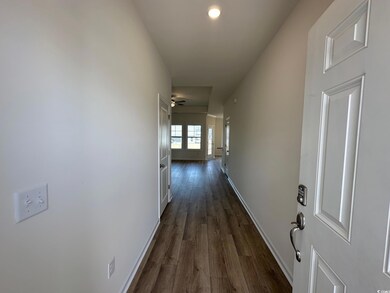 Hall featuring baseboards and dark wood-style flooring