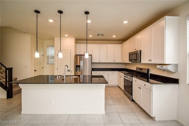 Kitchen with dark countertops, appliances with sta