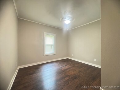 Empty room with crown molding, dark wood finished