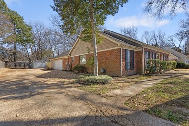 View of side of home with driveway, a garage, fenc