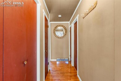 Hall with hardwood / wood-style floors and crown m