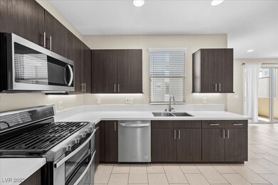 Kitchen with appliances with stainless steel finishes, dark brown cabinetry, recessed lighting, and modern cabinets