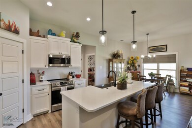Kitchen featuring an island with sink, white cabin