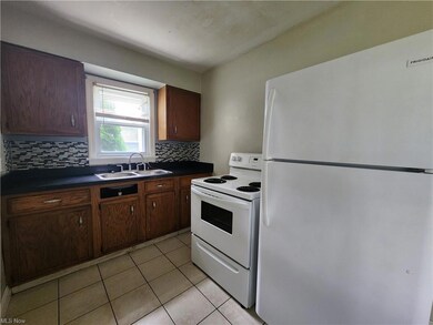 Kitchen with white appliances, dark brown cabinetr