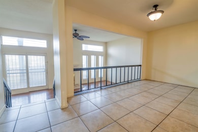 Spare room with a ceiling fan, light tile patterne
