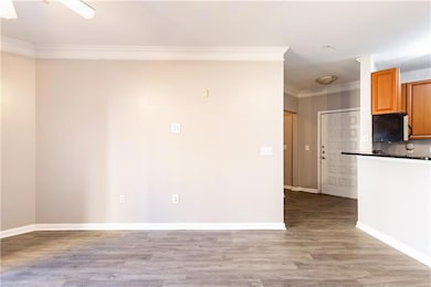 Empty room featuring ornamental molding, light wood-style flooring, and baseboards