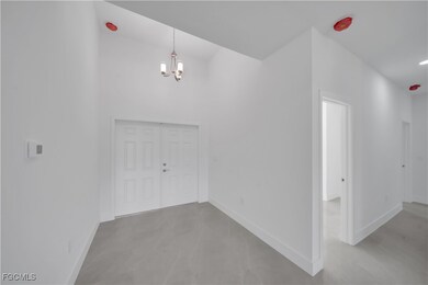 Foyer entrance with a chandelier and baseboards