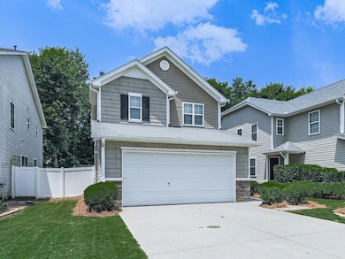 View of front facade featuring concrete driveway, an attached garage, and stone siding
