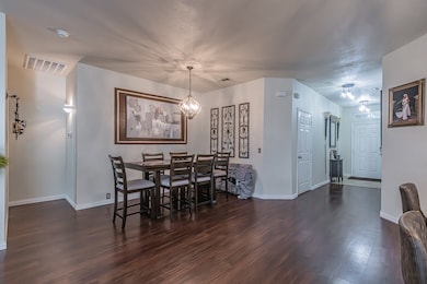 Dining space featuring dark wood-type flooring and a chandelier