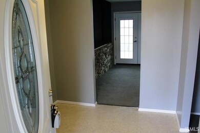Carpeted entryway with baseboards