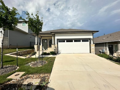 View of front of property featuring a garage, dri