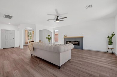 Living room featuring visible vents, arched walkw
