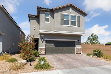 View of front of home featuring stone siding, stucco siding, a tiled roof, an attached garage, and decorative driveway