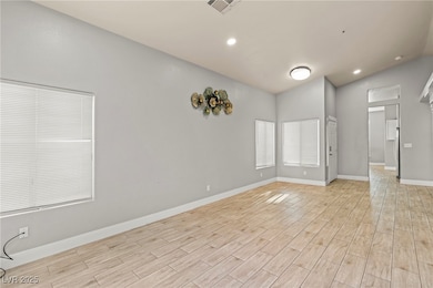 Empty room featuring lofted ceiling, light wood fi