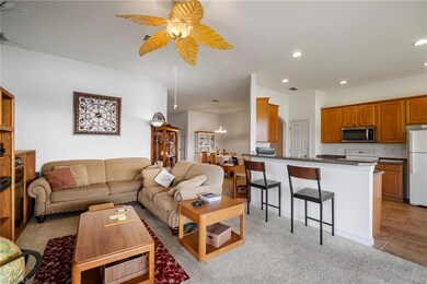 Living room with ceiling fan and light carpet