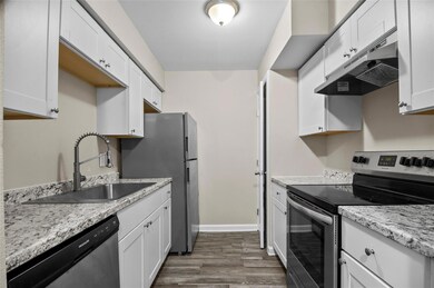 Kitchen featuring sink, vinyl plank flooring, appl