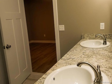 Full bathroom featuring double vanity and light wood-type flooring