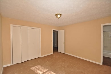 Unfurnished bedroom featuring carpet flooring, ens
