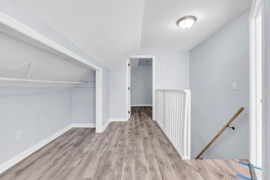 Corridor featuring an upstairs landing, wood finis