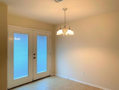 Dining room with french doors leading to backyard.