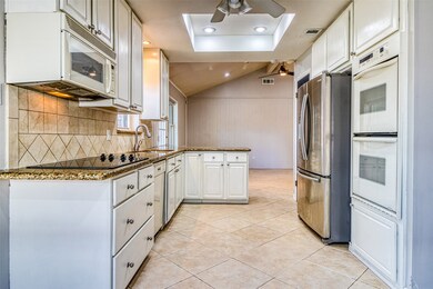 The tray ceiling and recessed lighting enhances the natural light streaming in from the backyard into the kitchen.  Note the double ovens and perfect layout of the kitchen.  Gas can easily be added for the cooktop if desired, as it backs to the exterior wall.