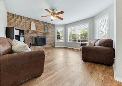 Living room with baseboards, light wood-type floor