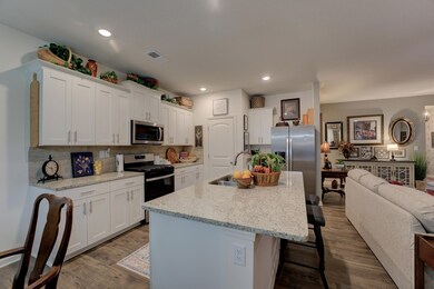Kitchen with an island with sink, white cabinetry,