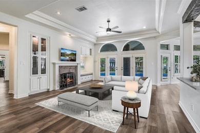 Living area featuring a ceiling fan, crown moldin